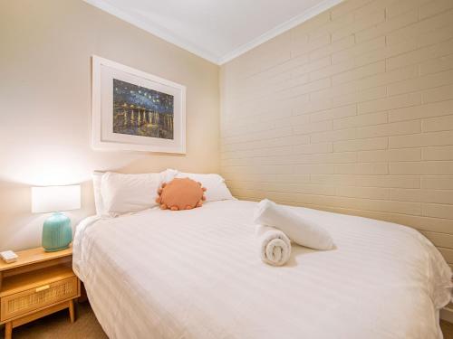 a bedroom with a white bed with a teddy bear on it at Snow Ski Apartments 35 in Falls Creek