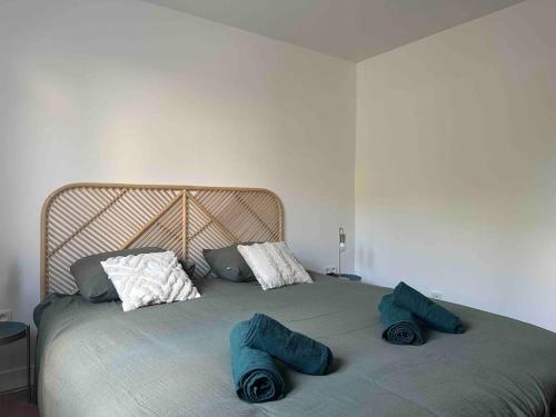 a bed with blue pillows on top of it at Maison Jardin Proche Paris in Villejuif