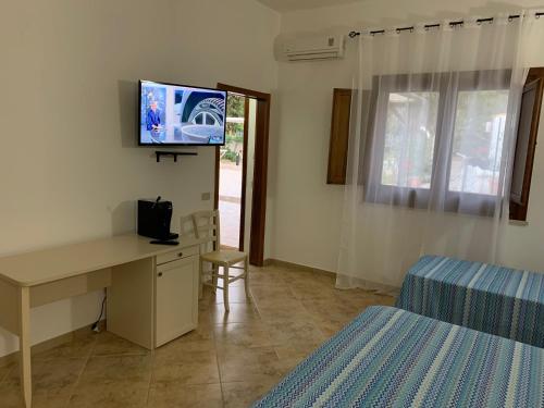TV a/nebo společenská místnost v ubytování L'oasi Una Pineta Sul Mare