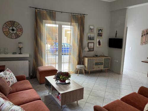 ein Wohnzimmer mit einem Sofa und einem Tisch in der Unterkunft Mairi’s Apartment in Nea Artaki