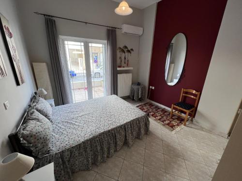 - une chambre avec un lit et un grand miroir dans l'établissement Mairi’s Apartment, à Nea Artaki