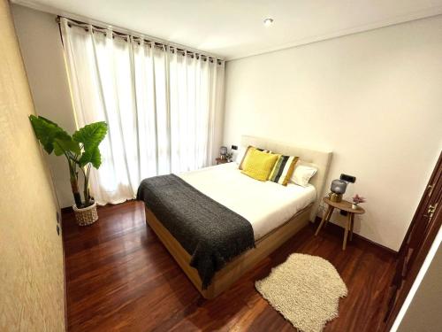 een slaapkamer met een bed en een groot raam bij Apartamento Olívico con Parking in Vigo