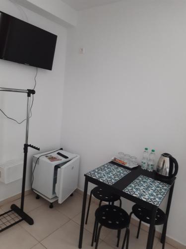 Habitación con mesa, microondas y TV. en Pensiunea Transilvania, en Odorheiu Secuiesc