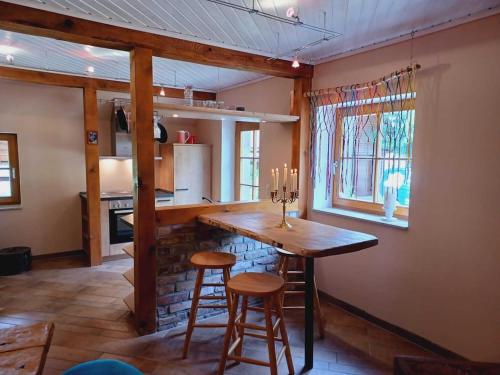 a kitchen with a wooden table and some stools at super cozy holiday apartment in a maritime style in Steinfeld