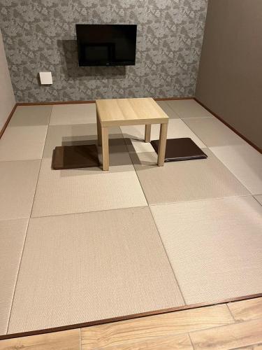 a living room with a table and a tv at Asagaya House in Tokyo