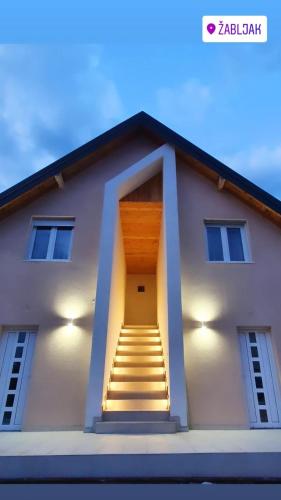 a stairway leading to a white building with a door at Iva Lux Apartments in Žabljak