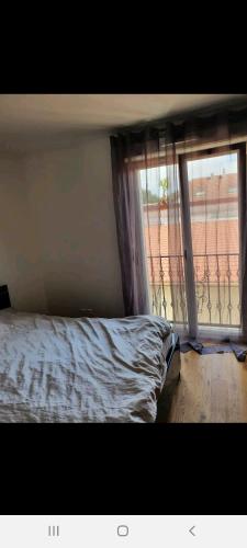 - une chambre avec un lit à côté d'une fenêtre dans l'établissement Villa coubron Montfermeil, à Montfermeil