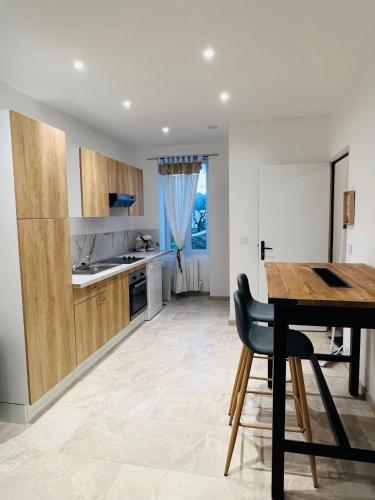 une cuisine avec une table en bois et une salle à manger dans l'établissement LE JEAN JAURÈS Arrivée Autonome, à Vierzon