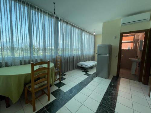 ティラナにあるBajovah Apartments & Restaurantのテーブルと椅子、窓が備わる客室です。