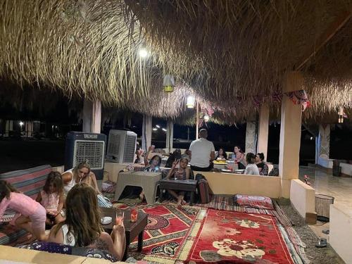 a group of people sitting in a restaurant at Al Khalil Beach Camp in Nuweiba