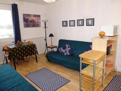 un salon avec un canapé vert et une table dans l'établissement Studio à 50m de la plage, 3 couchages, parking gratuit, animaux acceptés - FR-1-224C-73, à Saint-Jean-de-Monts