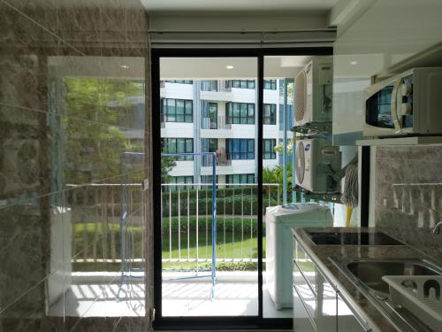 a kitchen with a sliding glass door to a balcony at 2 Floor - Centrio Condominium near Central Shopping Mall and Phuket Old town in Phuket