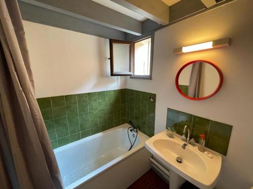 une salle de bain avec une baignoire, un lavabo et un miroir dans l'établissement Villa Patio Vintage Proche du Port avec Terrasse et Parking - FR-1-413-100, à Capbreton