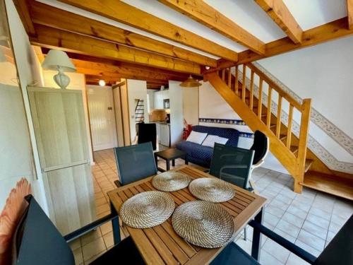 un salon avec une table et des chaises et un escalier dans l'établissement Maison proche plage avec jardinet, 3 pièces, 40m², parking privé, animaux acceptés - FR-1-478-131, à Saint-Pierre-Quiberon