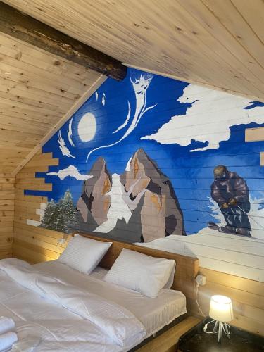 a room with two beds and a mural on the wall at Skupis kokhebi in Mestia