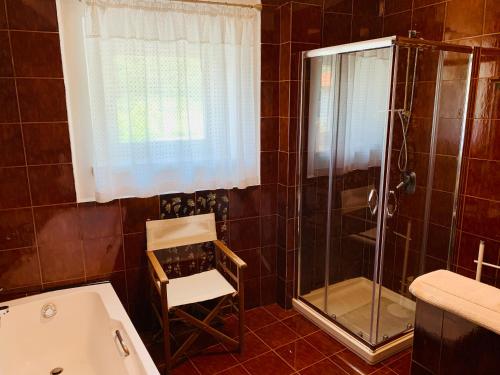 y baño con ducha y silla. en MICASA ESTUCASA slow holiday, en Padergnone