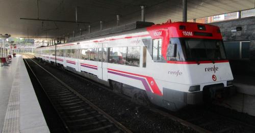 a red and white train pulling into a train station at Exclusivo "Gran Bilbao" Suite Deluxe PARKING OPCIONAL in Santurce