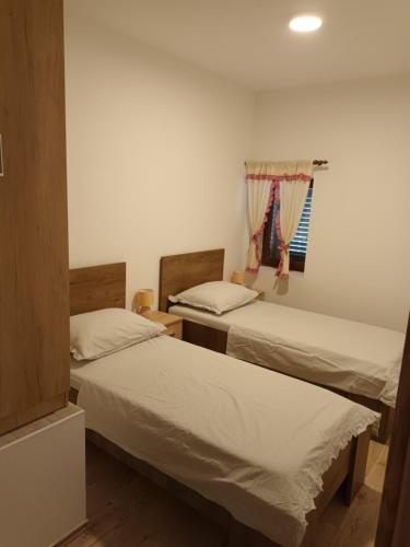2 Betten in einem Zimmer mit Fenster in der Unterkunft Kuća za odmor Grupković in Ploče