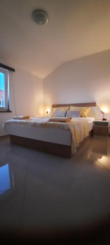 a bedroom with a large bed and a window at Apartments Ivan in Povljana