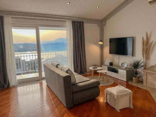a living room with a couch and a television at Oskar in Podstrana