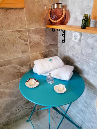 a blue table with towels and plates on it in a bathroom at Archipelagos Kimolos sea view in Kimolos
