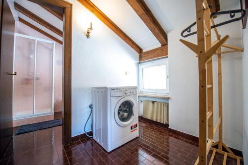 a laundry room with a washer and a window at Apartments Raphael in Ortisei
