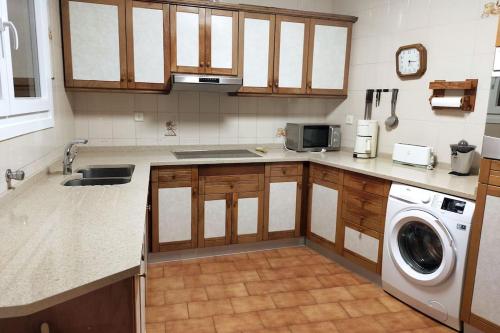 a kitchen with a sink and a washing machine at Las Mañanitas in Tafalla