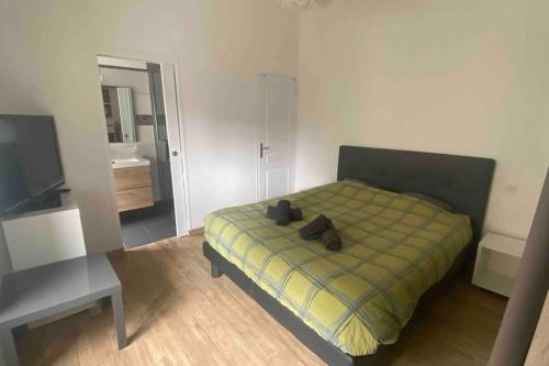 Schlafzimmer mit einem Bett, einem TV und einem Tisch in der Unterkunft Appartement Dol de Bretagne centre in Dol-de-Bretagne