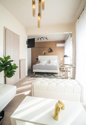 a bedroom with a white bed and a table at John's Hotel in Chalkida