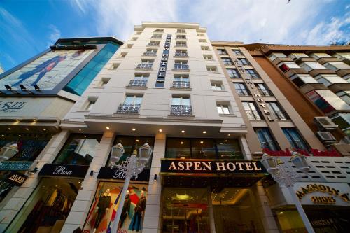 Aspen Hotel & SPA Istanbul Old City في إسطنبول: مبنى أبيض طويل مع علامة أمامه