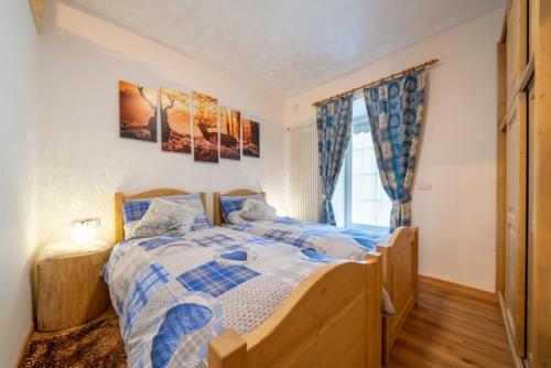 - une chambre avec un lit et une couette bleue et blanche dans l'établissement Appartamento Valmaor, à Predazzo