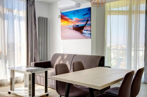 a living room with a table and a couch at Apartament Melody by Alz in Mamaia Nord