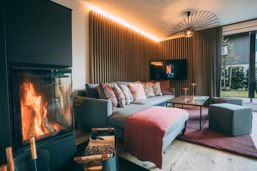 a living room with a couch and a fireplace at Boutique ChaletS Alpi - Private Sauna & Cinema in Garmisch-Partenkirchen