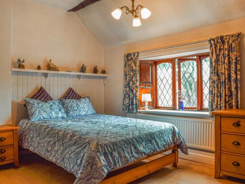 um quarto com uma cama e uma janela em Weavers Cottage em Barnsley