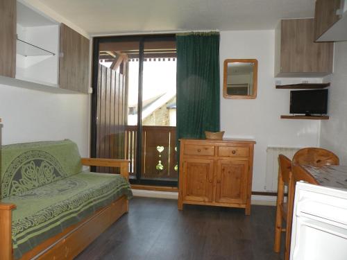 ein Wohnzimmer mit einem Sofa und einem Fenster in der Unterkunft Au Coeur De La Station in Les Deux Alpes