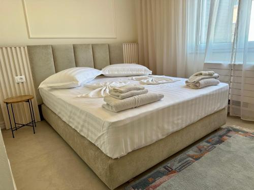 a bedroom with a large bed with towels on it at Sea View Apartments ELDO in Durrës