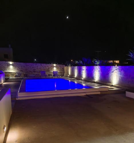 a swimming pool at night with blue lights at Ftelia Breeze in Klouvas