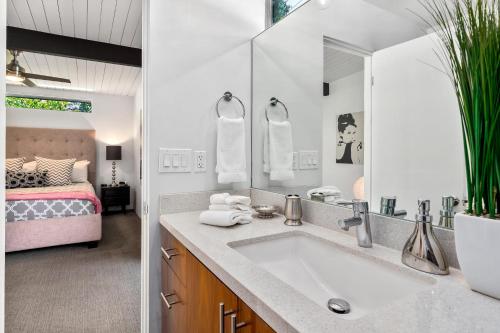 a bathroom with a sink and a bed at Aqua House in Palm Springs