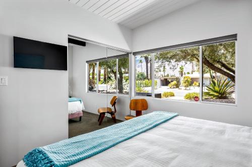 a bedroom with a bed and a large window at Aqua House in Palm Springs