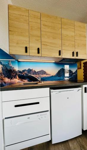 une cuisine avec des appareils électroménagers blancs et des armoires en bois dans l'établissement L'AnsloBoys Montagne J4, à Les Deux Alpes