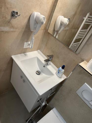 a bathroom with a white sink and a mirror at Comfort Rooms Pogradec in Pogradec