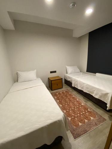 a room with two beds and a rug at Gala Otel Edirne in Edirne