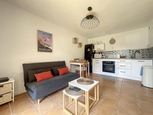 un salon avec un canapé et une cuisine dans l'établissement Appartement avec jardin à 30m de la plage, à Villers-sur-Mer