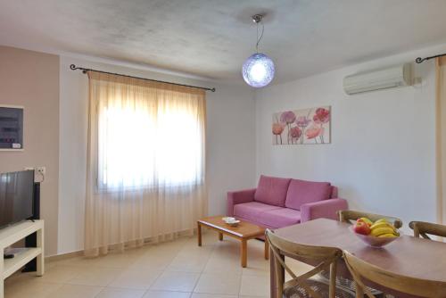 a living room with a purple couch and a table at Myrtilo cottage in Votsi