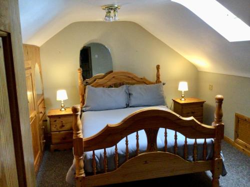 a bedroom with a wooden bed and two night stands at Swilly View House in Ramelton