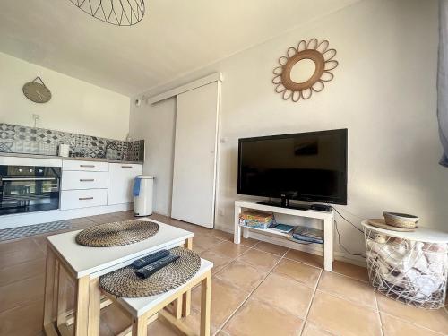 un salon avec une télévision à écran plat sur un mur dans l'établissement Appartement avec jardin à 30m de la plage, à Villers-sur-Mer
