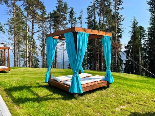 un letto in un campo con baldacchino blu di 103 View Park Hotel & SPA a Panichishte