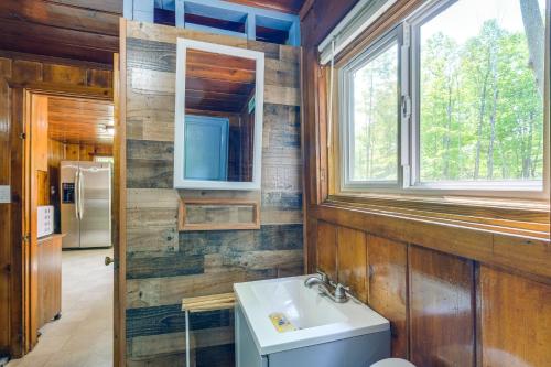 a bathroom with a sink and a window at Charming Michigan Cottage with Sunroom and Lake Access in Hubbard Lake