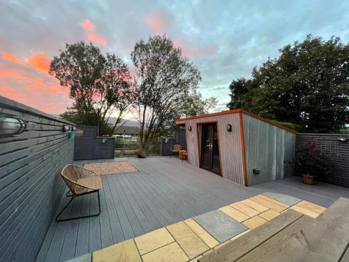 a deck with a smallshed with a chair on it at Stylish, central studio with kitchen & large deck in Fort William