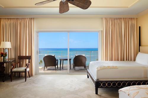 a bedroom with a bed and a view of the ocean at The Kahala Hotel and Resort in Honolulu